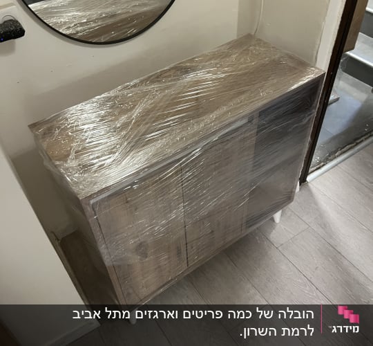 רהיט עטוף בניילון ליד מראה עגולה